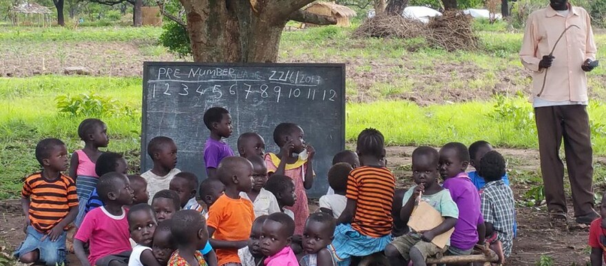 Pupils attending a lesson under a tree in South Sudan. [Photo: Anglican Aid]