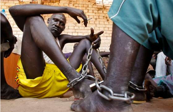 Shackled inmates sit in the yard in Rumbek Central Prison in Rumbek, South Sudan, (Photo/EPA)