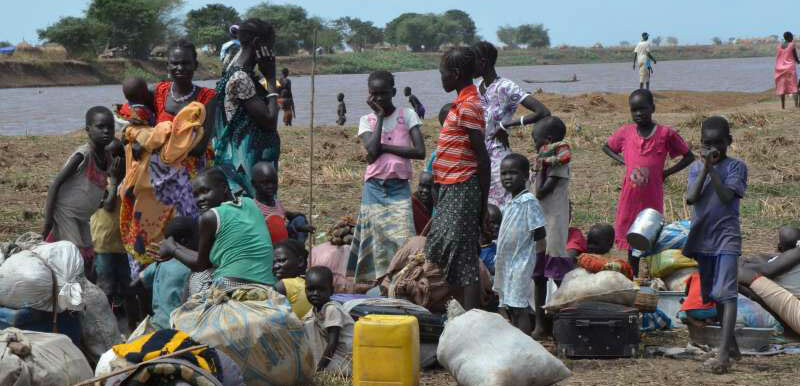 A group of displaced women and children rest on Ethiopian territory after crossing the Baro River from South Sudan. [Photo: UNHCR]