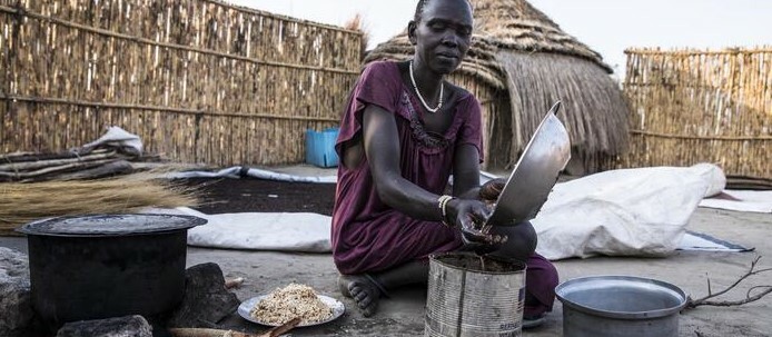 Nyabany Mun Roah prepares a local dish from sorghum for her family outside their home in Karam, Uror County of Jonglei State.© WFP/Gabriela Vivacqua