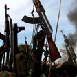 Rebel fighters hold up their rifles as they walk in front of a bushfire in a rebel-controlled territory in Upper Nile State, South Sudan February 13, 2014. [Photo: REUTERS/Goran Tomasevic]