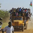 Residents hang from a bus and hold a South Sudanese flag in the disputed Abyei region of Sudan. [Photo: ALI NGETHI/AFP via Getty Images]