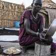 Nyabany Mun Roah prepares a local dish from sorghum for her family outside their home in Karam, Uror County of Jonglei State.© WFP/Gabriela Vivacqua